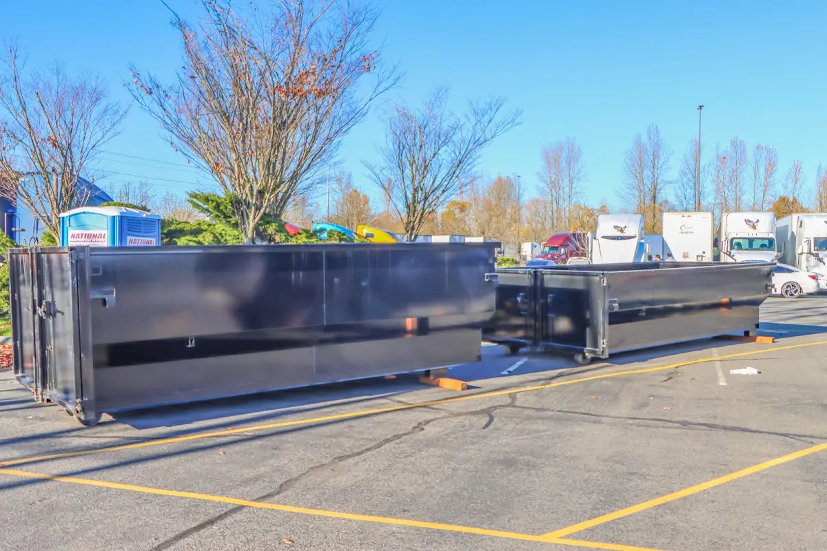 Professional dumpster rental service with roll-off container on residential driveway in Mashpee